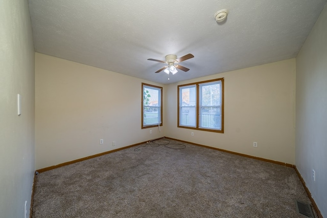 spare room with ceiling fan, light colored carpet, and a textured ceiling