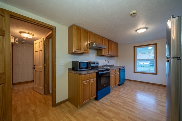 kitchen featuring sink, black appliances, a textured ceiling, and light wood-type flooring