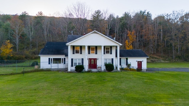 greek revival house featuring covered porch and a front yard