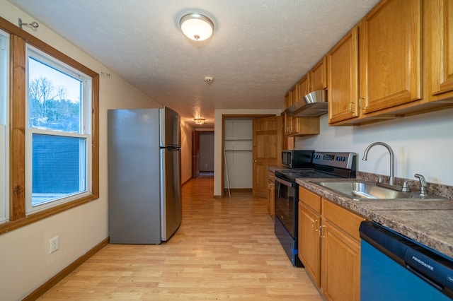 kitchen featuring stainless steel refrigerator, dishwasher, sink, light hardwood / wood-style flooring, and black electric range oven