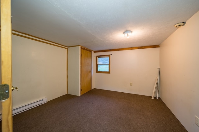 basement featuring dark colored carpet, a textured ceiling, and a baseboard radiator