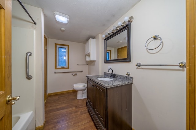 bathroom featuring vanity, wood-type flooring, a textured ceiling, and toilet