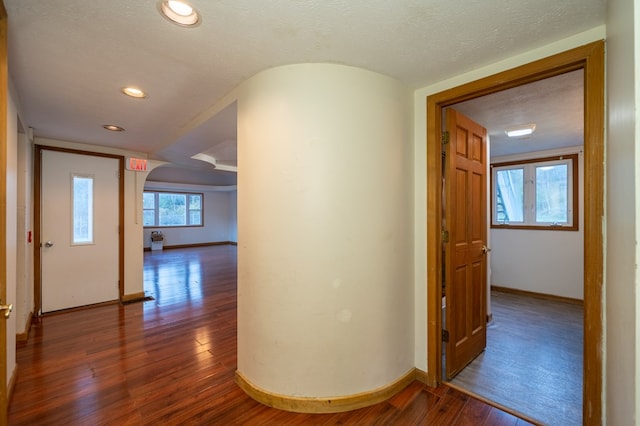 hallway with dark wood-type flooring and a textured ceiling