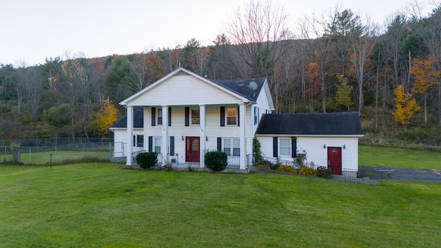 greek revival house featuring a porch and a front lawn