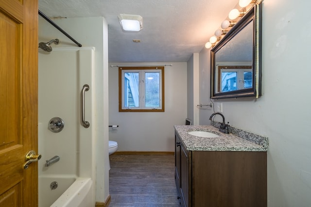 bathroom featuring vanity, wood-type flooring, a textured ceiling, and toilet