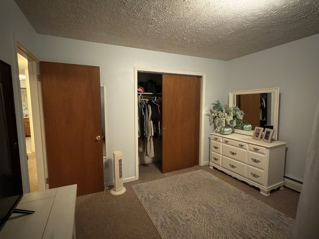 bedroom with dark carpet, baseboard heating, a textured ceiling, and a closet