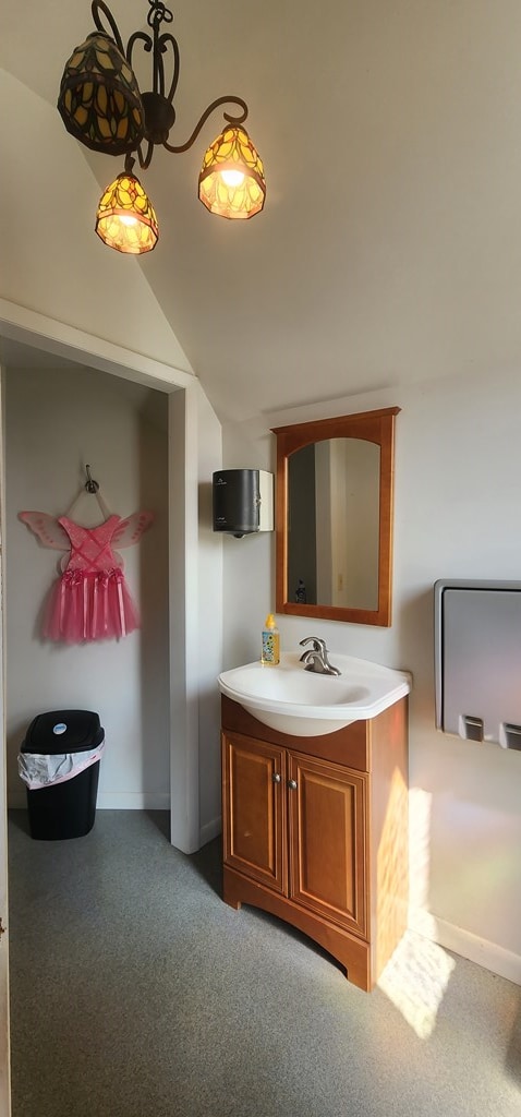 bathroom featuring vanity and lofted ceiling