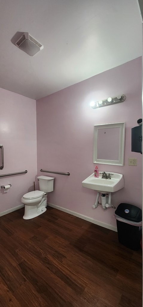 bathroom with hardwood / wood-style flooring, toilet, and sink