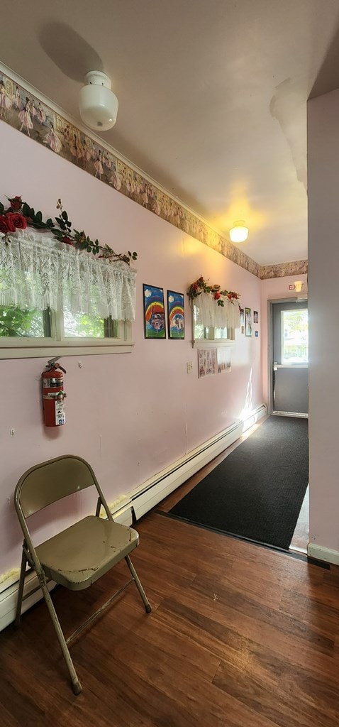 interior space with dark wood-type flooring and a baseboard radiator