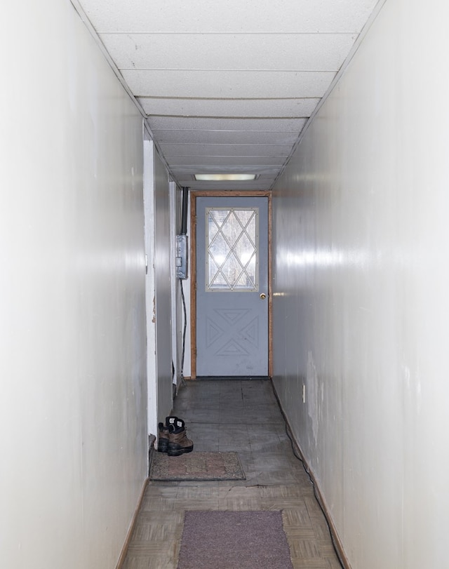 doorway to outside with a drop ceiling