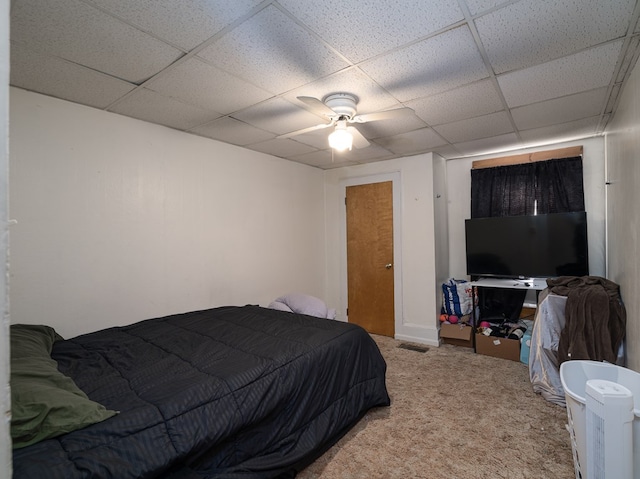 bedroom with ceiling fan, a drop ceiling, visible vents, and light colored carpet