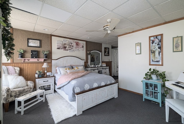 bedroom featuring a paneled ceiling, ceiling fan, and dark colored carpet