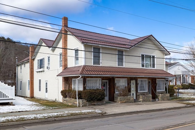 view of front of home with metal roof and a chimney