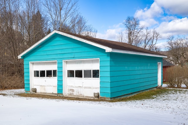 snow covered garage featuring a garage