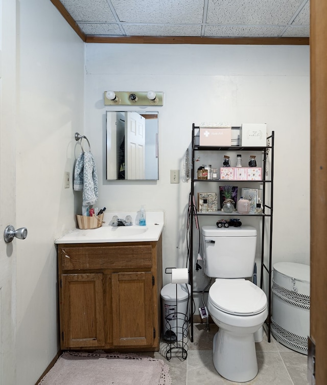 bathroom featuring a paneled ceiling, baseboards, vanity, and toilet