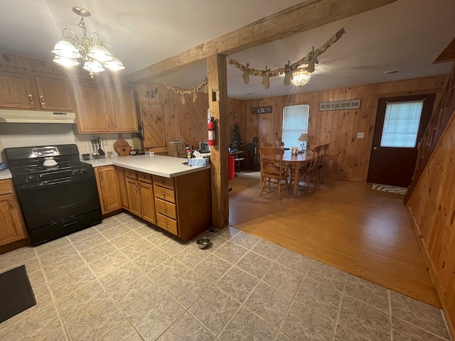 16 Quarry Ln, Galeton, PA 16922 - kitchen featuring wooden walls, an inviting chandelier, gas stove, light countertops, and under cabinet range hood