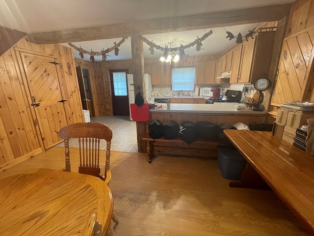 16 Quarry Ln, Galeton, PA 16922 - kitchen with wood walls, white microwave, light wood-style floors, under cabinet range hood, and gas range oven