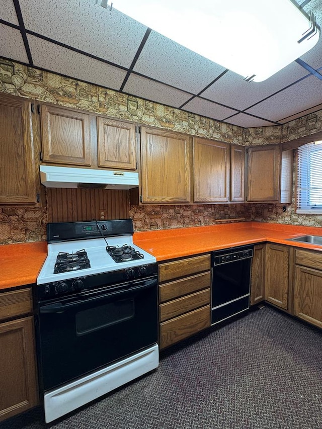 kitchen with range with gas cooktop, black dishwasher, dark colored carpet, sink, and a drop ceiling