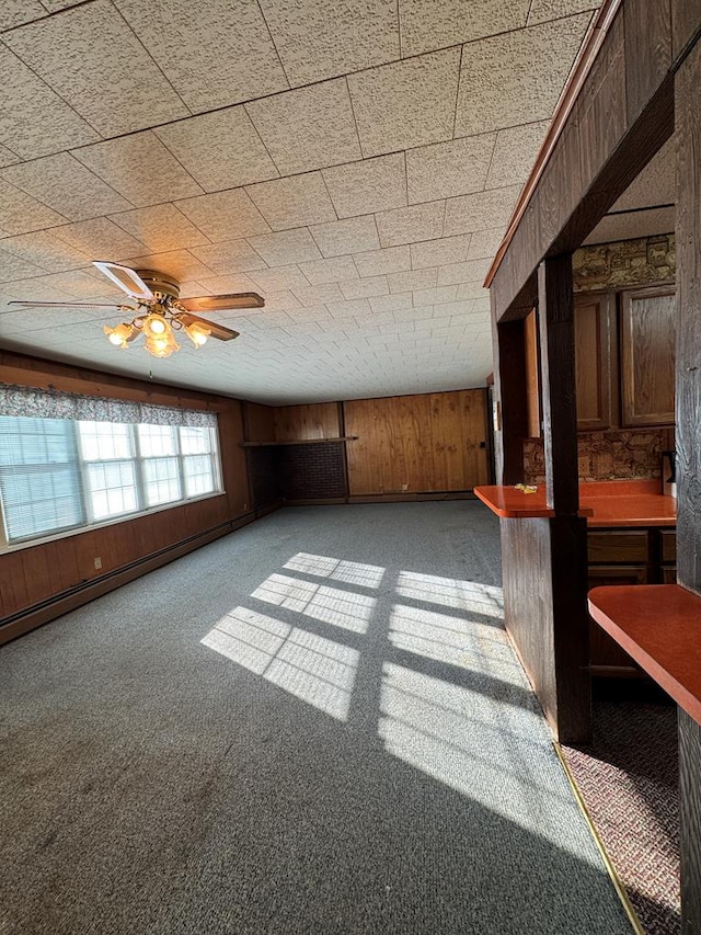 interior space featuring ceiling fan and wood walls