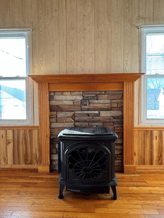 room details featuring a wood stove, wood-type flooring, and wooden walls