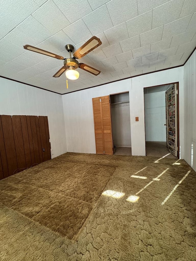 unfurnished bedroom with ceiling fan, carpet floors, and multiple closets