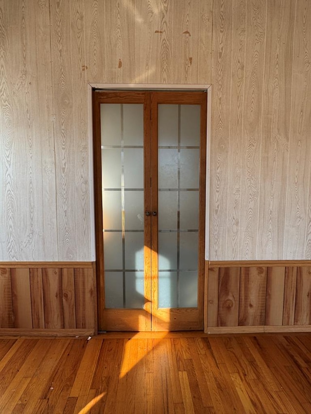 empty room featuring wood walls and hardwood / wood-style flooring