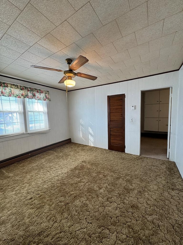 unfurnished bedroom featuring ceiling fan, a baseboard heating unit, and carpet floors