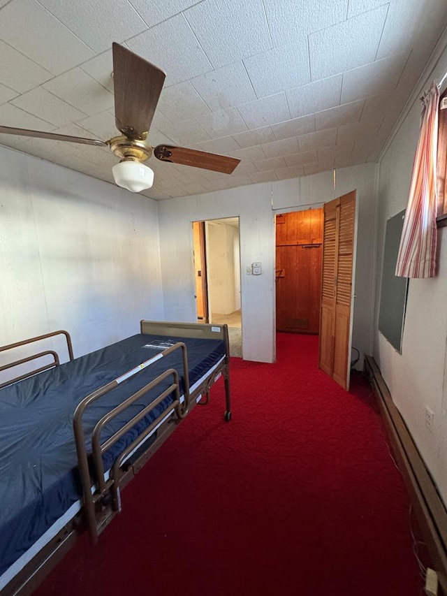 bedroom featuring ceiling fan, baseboard heating, and carpet