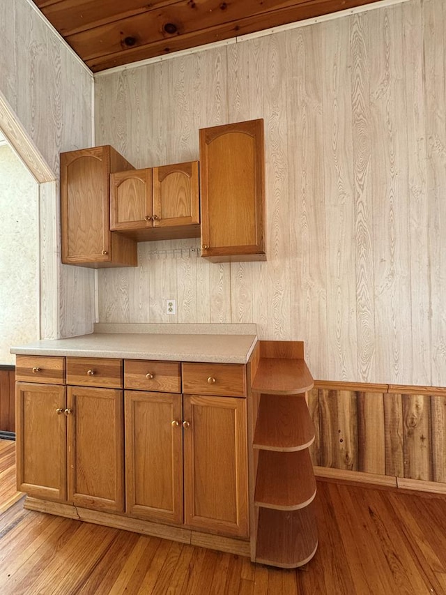 kitchen with wood ceiling, light hardwood / wood-style floors, and wood walls