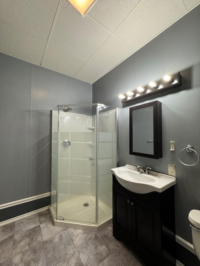 bathroom featuring a shower with shower door, toilet, and vanity