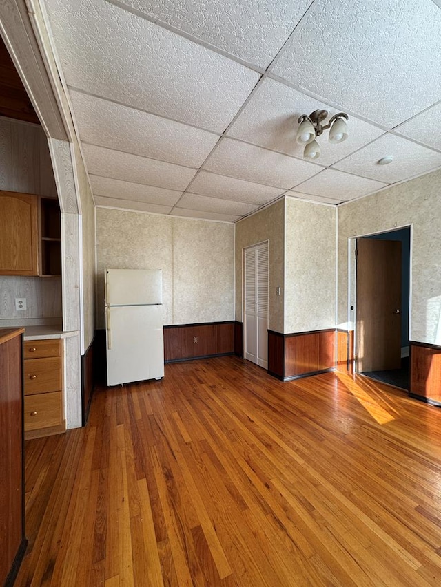 interior space featuring a paneled ceiling and wood-type flooring