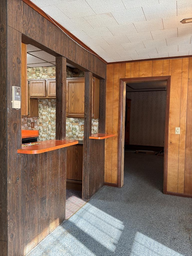 bar with light carpet and wood walls