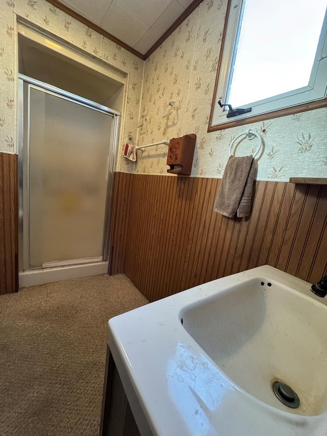 bathroom with crown molding, walk in shower, wood walls, and vanity