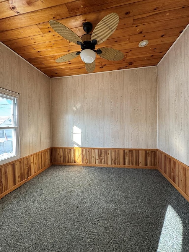 carpeted spare room with ceiling fan and wooden ceiling