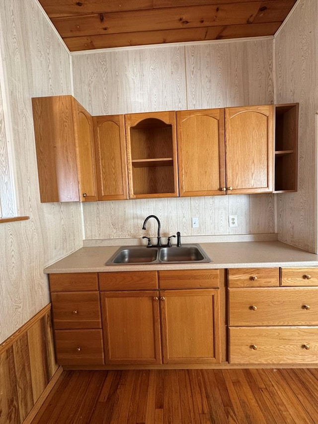 kitchen featuring sink, hardwood / wood-style floors, and wooden walls