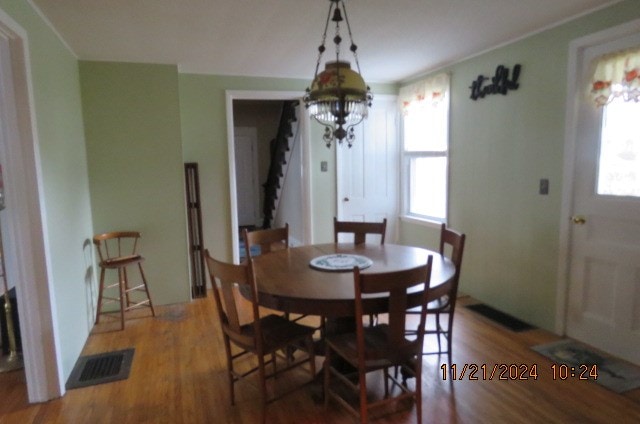 dining room with wood-type flooring and an inviting chandelier