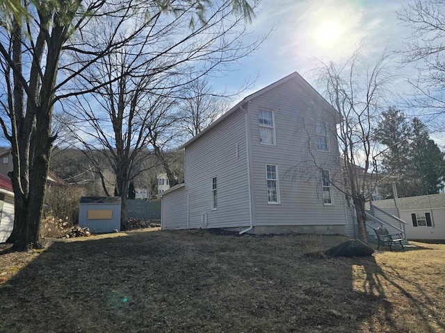 view of side of property with a storage unit and an outbuilding