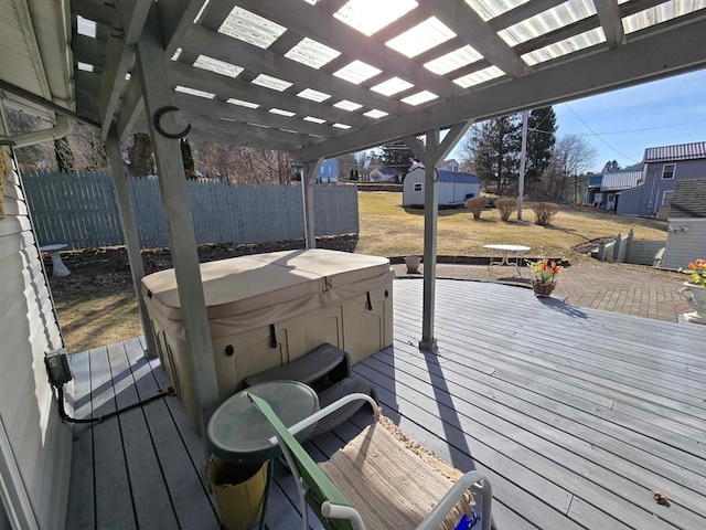 wooden terrace with outdoor dining space, fence, a pergola, a hot tub, and an outdoor structure