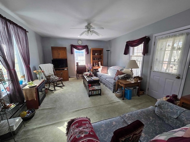 living area with light carpet, plenty of natural light, and a ceiling fan