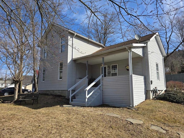 back of property with a porch, stairs, and a yard