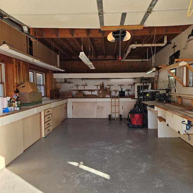 garage with a garage door opener and a workshop area