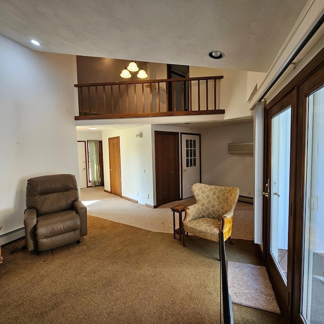 sitting room with carpet floors, a baseboard radiator, and a high ceiling