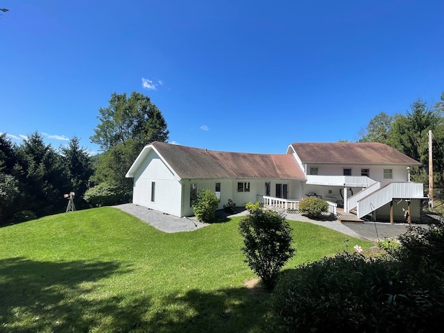 rear view of property with a yard and a deck