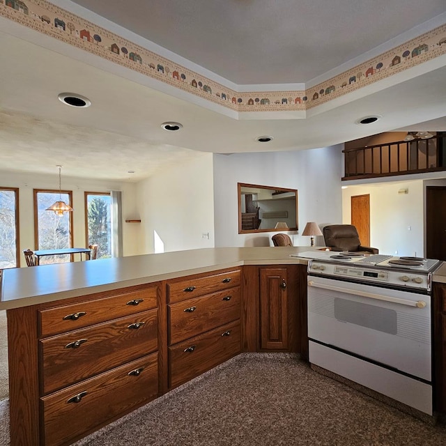 kitchen with electric stove, pendant lighting, dark colored carpet, a raised ceiling, and kitchen peninsula