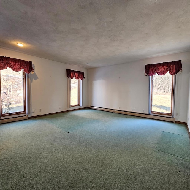 carpeted spare room with a textured ceiling and baseboard heating