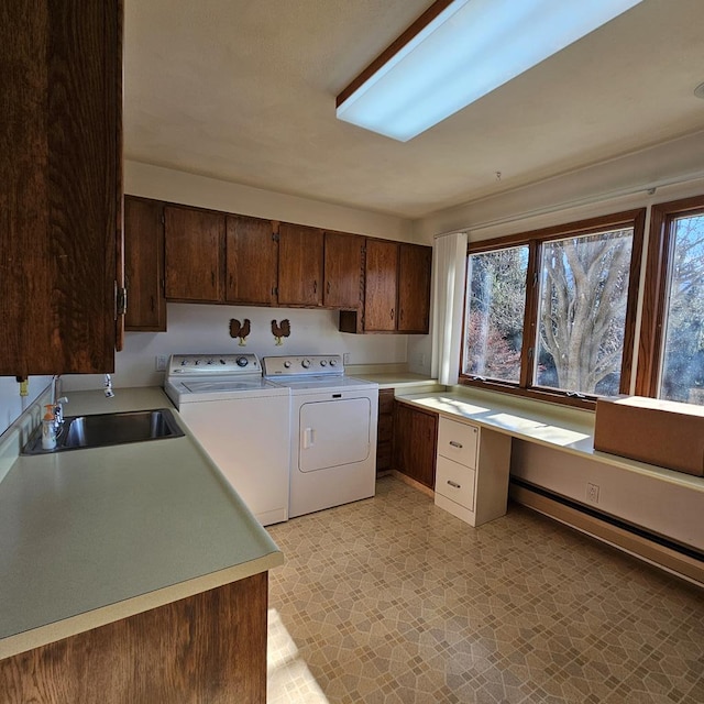 washroom featuring cabinets, a baseboard radiator, separate washer and dryer, and sink