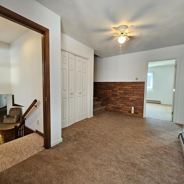 interior space featuring a baseboard radiator, ceiling fan, and a closet