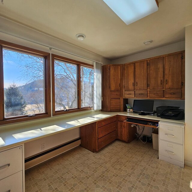 unfurnished office with a baseboard radiator and built in desk