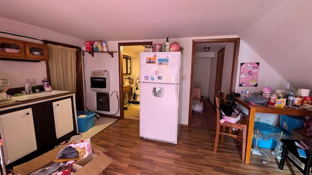 kitchen with dark hardwood / wood-style flooring, white refrigerator, heating unit, and vaulted ceiling