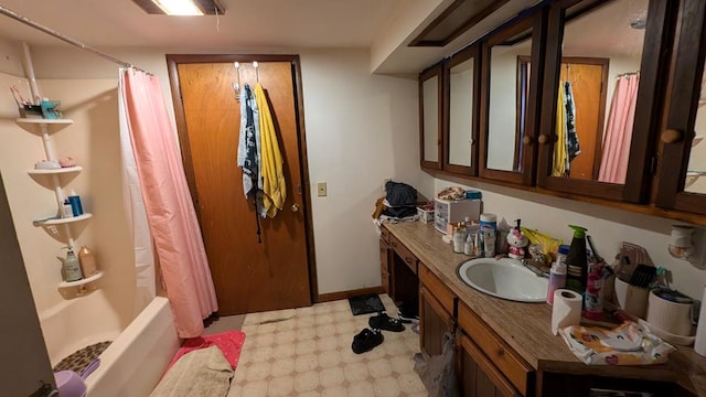 bathroom featuring shower / bath combo with shower curtain and vanity